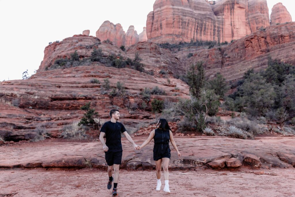 Adventurous couple hiking in Sedona for their Cathedral Rock Engagement Photos