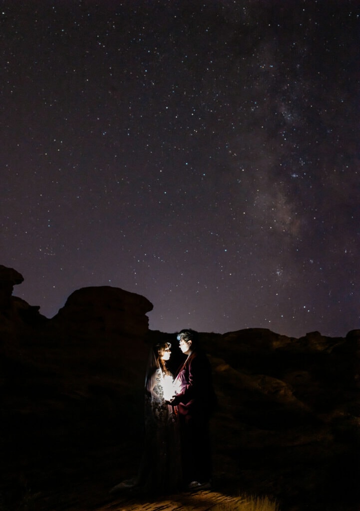 couple holds light under the stars 