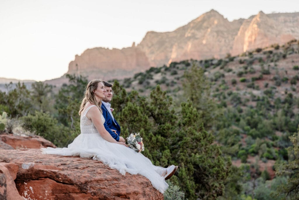 wedding couple sits at Flagstaff Arizona cliff edge elopement location