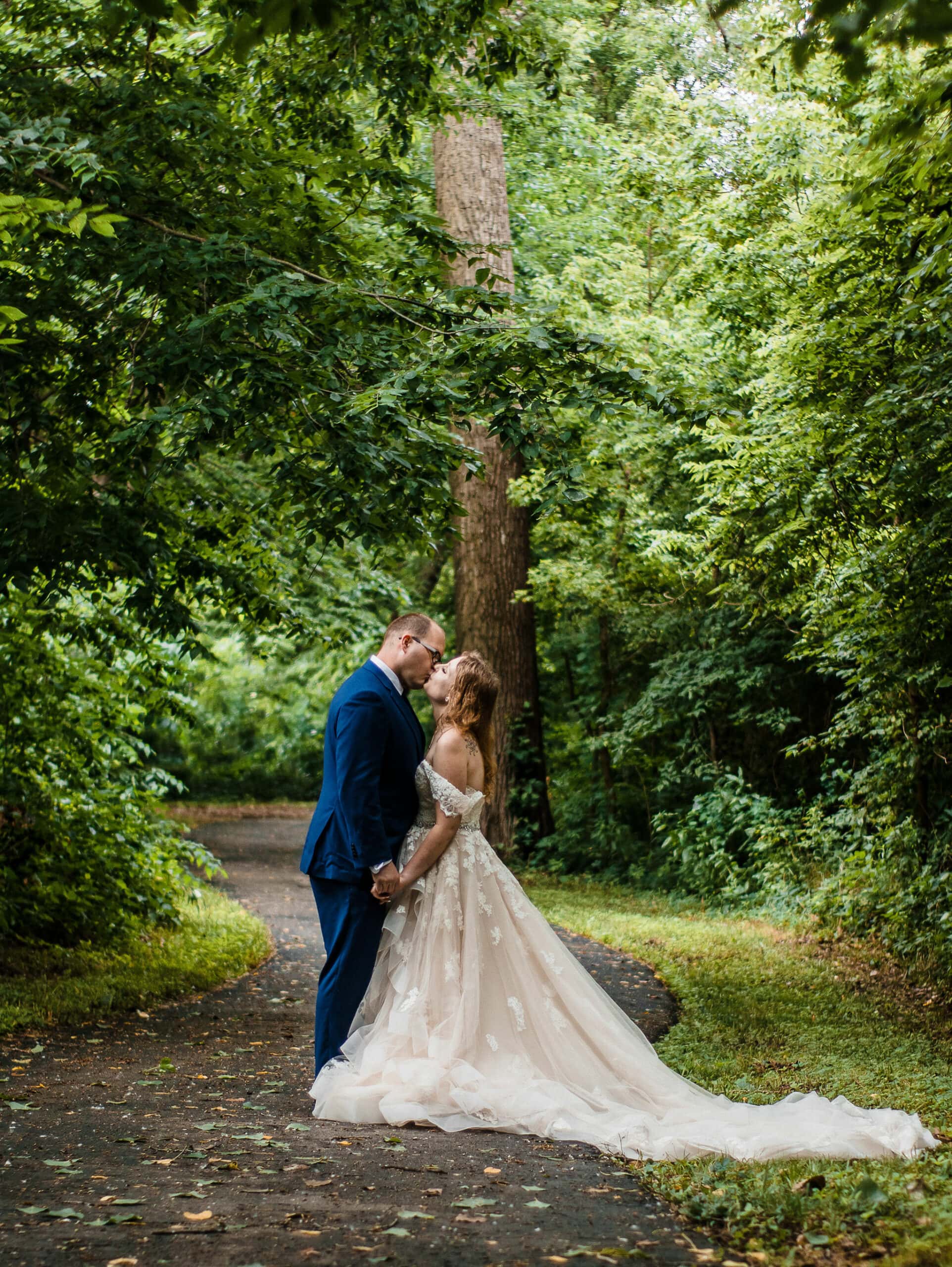 couple kisses under trees at outdoor elopement location