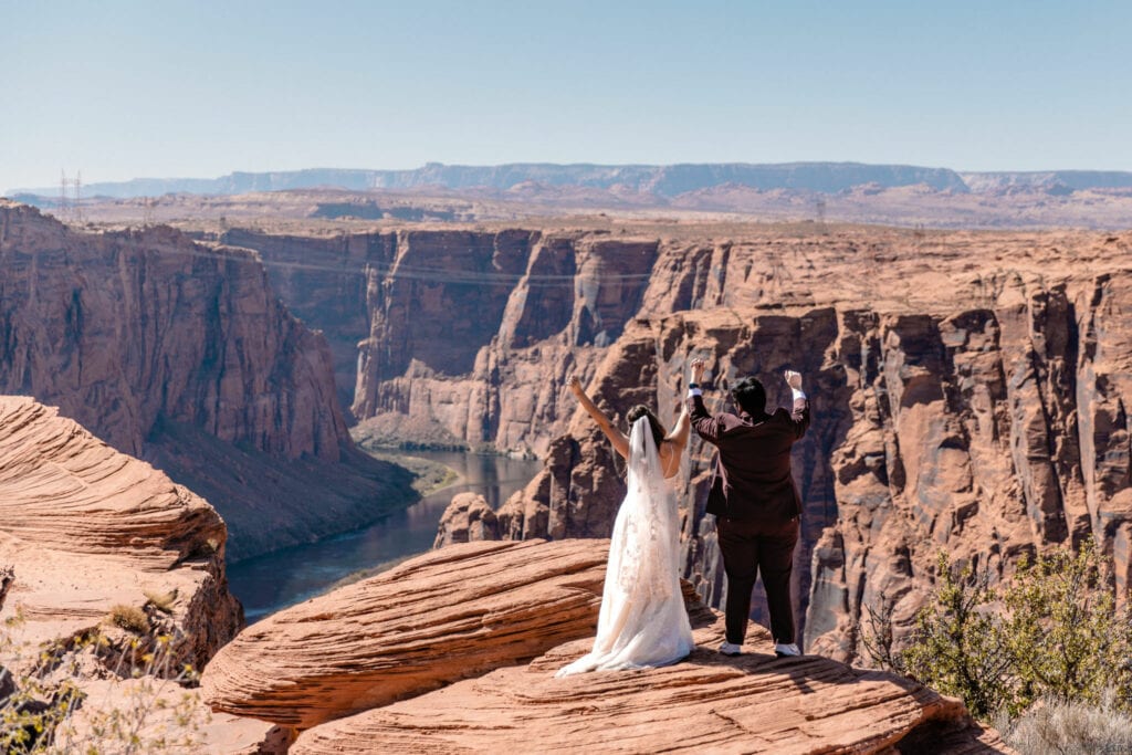 couple holds hands over cliff at Arizona elopement