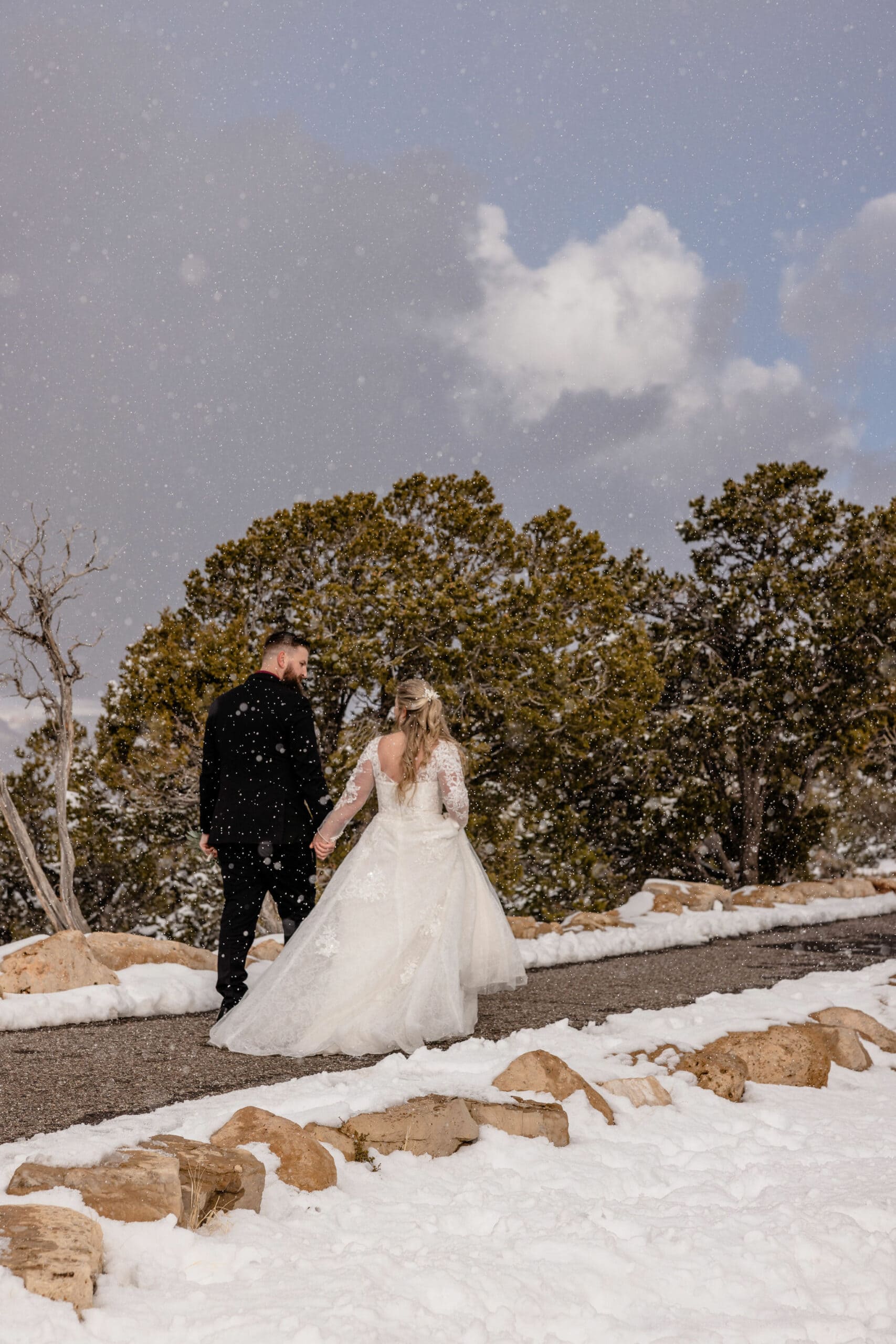 couple walks along snow-covered Grand Canyon elopement location